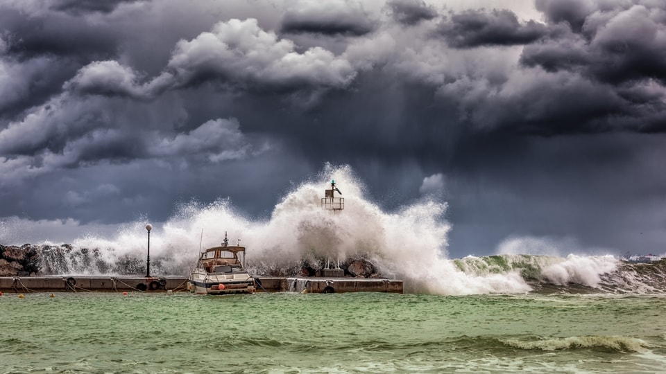 Crashing waves with boats being turned over