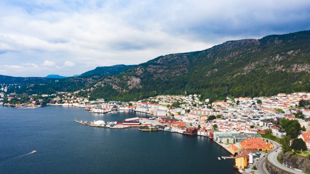 Rolling mountains in the background, with a roaring city on the coastline
