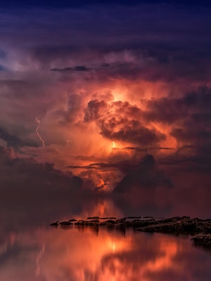 Lightning storm on the ocean, with a reflection