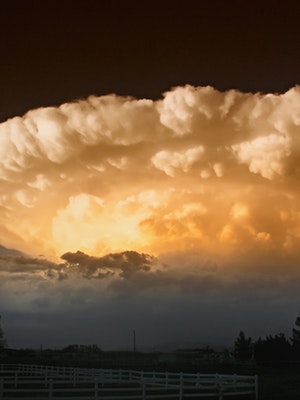 Huge wall of clouds rolling in towards the light of the sun